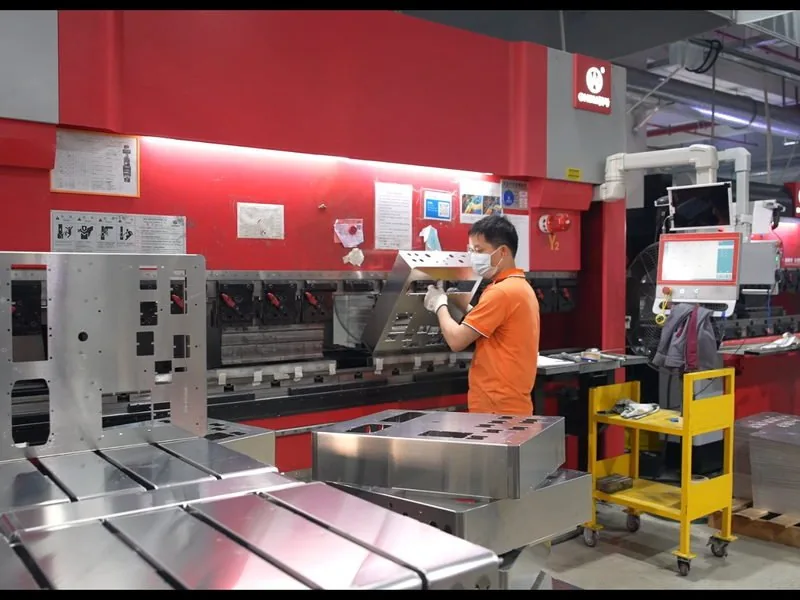 Operator forming a sheet metal cabinet panel on a press brake